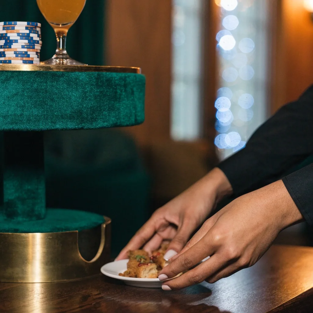 Stolik w strefie restauracyjnej Pavillon Azur, obok żetony i szklanka na filcowym brzegu