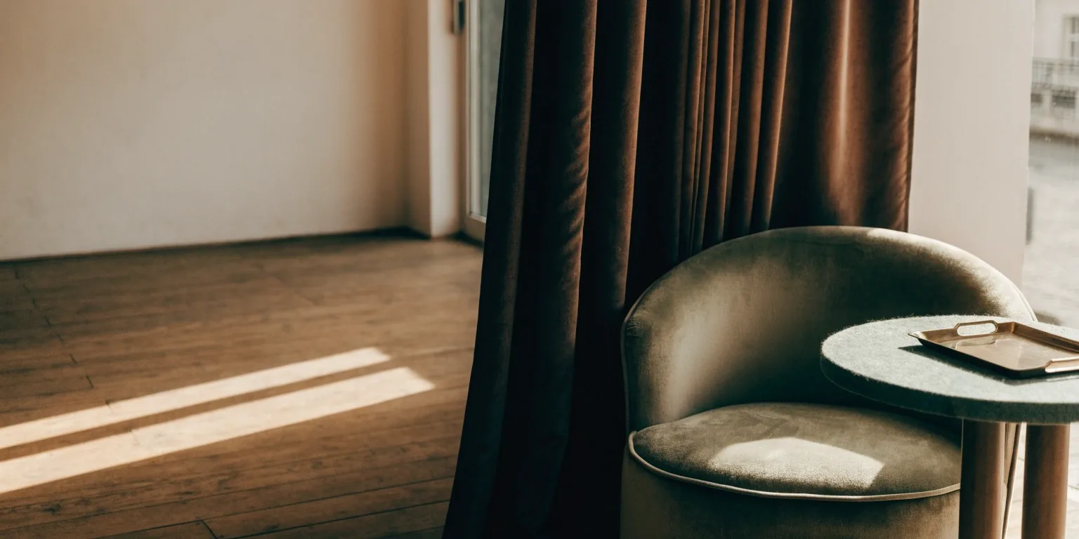 Wnętrze lounge w godzinach popołudniowych — puste fotele, stolik i kontuar w głębi